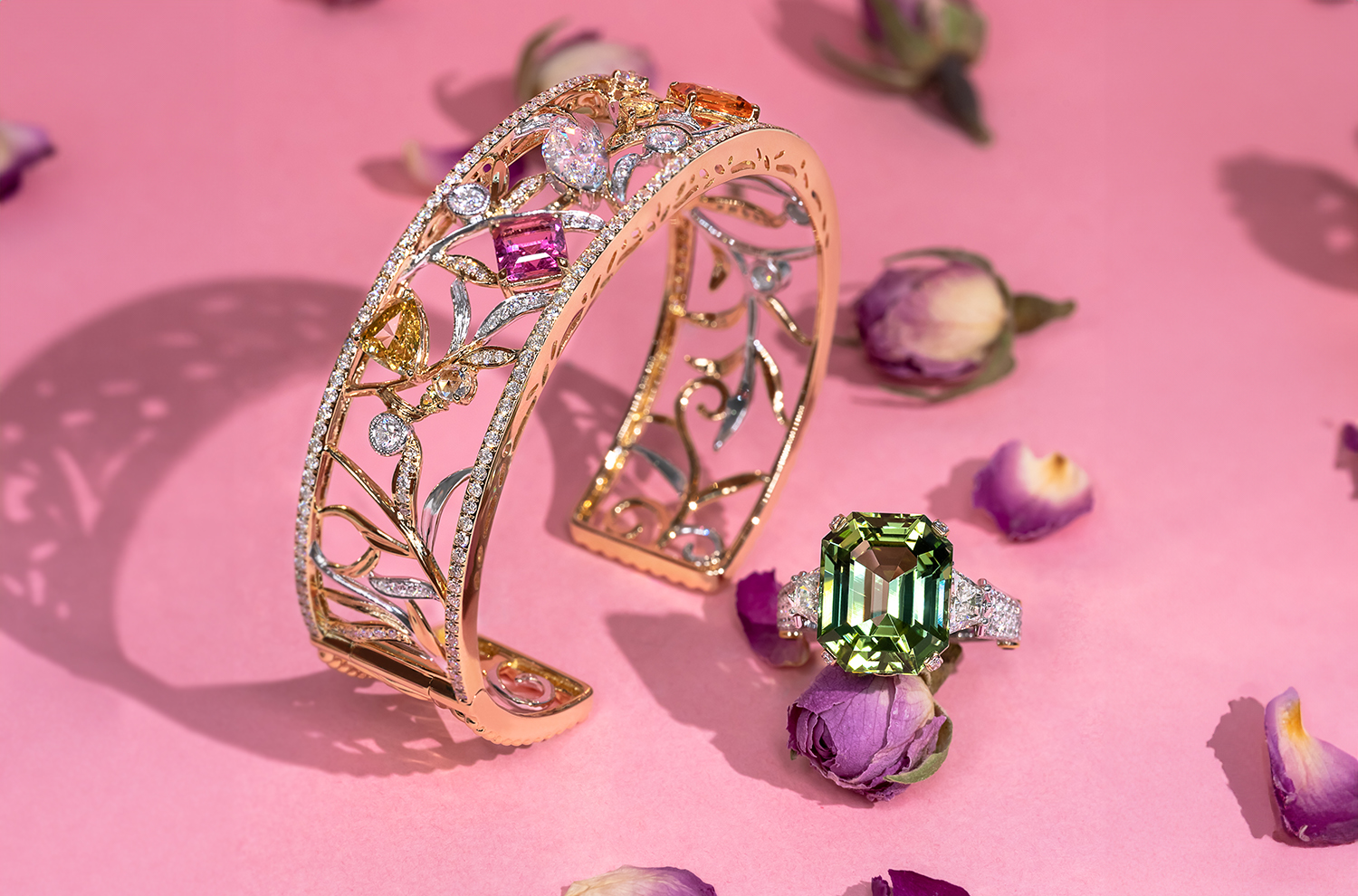 Bespoke jewellery pieces made by MADLY: a floral bangle with multi-coloured gemstones and a green Tourmaline cocktail ring.